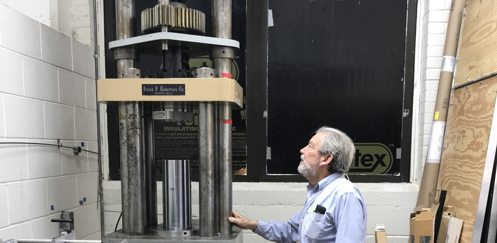 John Logan looking at the Large Sample Rig in the rock-deformation lab at the Center for Tectonophysics, Texas A&M University, on the occasion of the 50th anniversary of the Center in 2018.  Dr. Logan designed the LSR and joined countless students and colleagues in conducting great scientific investigations using this tool.